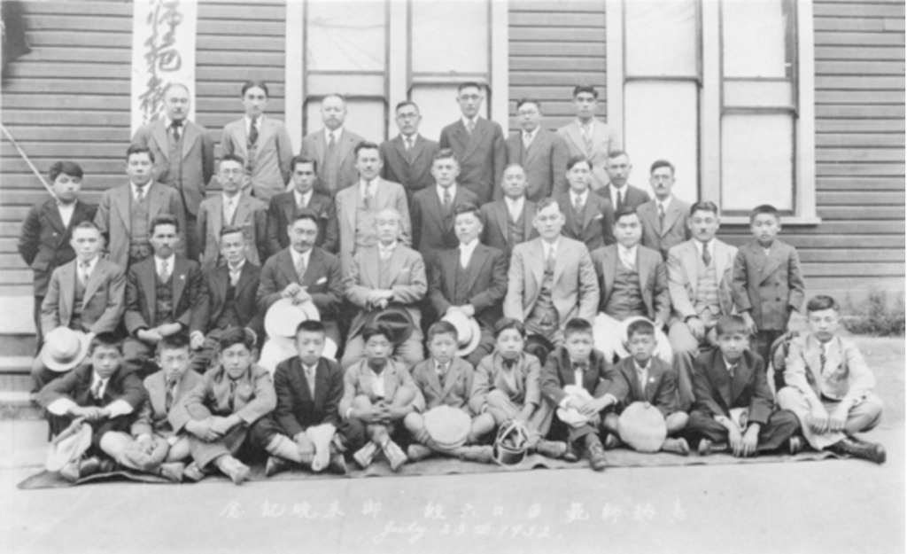 An Outdoor Group Portrait of Estsuji Morii, Dr Jigaro Kano, Mr Kamino and a Jigoro Kano Visit 1932 Large Group of People in Front of the Exterior of a Building.